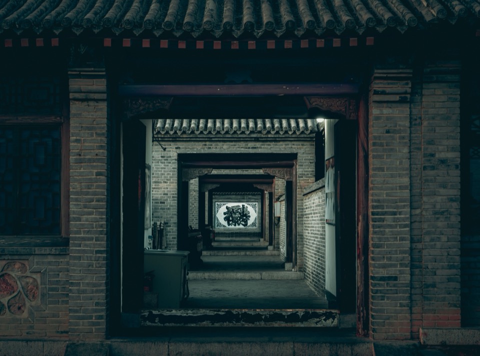 中式庭院里层层递进的门洞，尽头是一面题字照壁